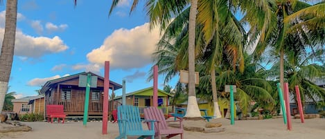 A beach area with colorful chairs and a wooden building with a sloped roof.