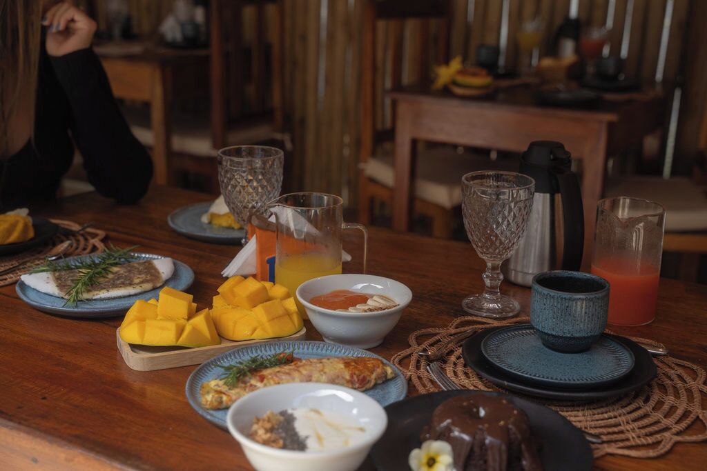 A dining table with various dishes, drinks, and a person sitting at the table.