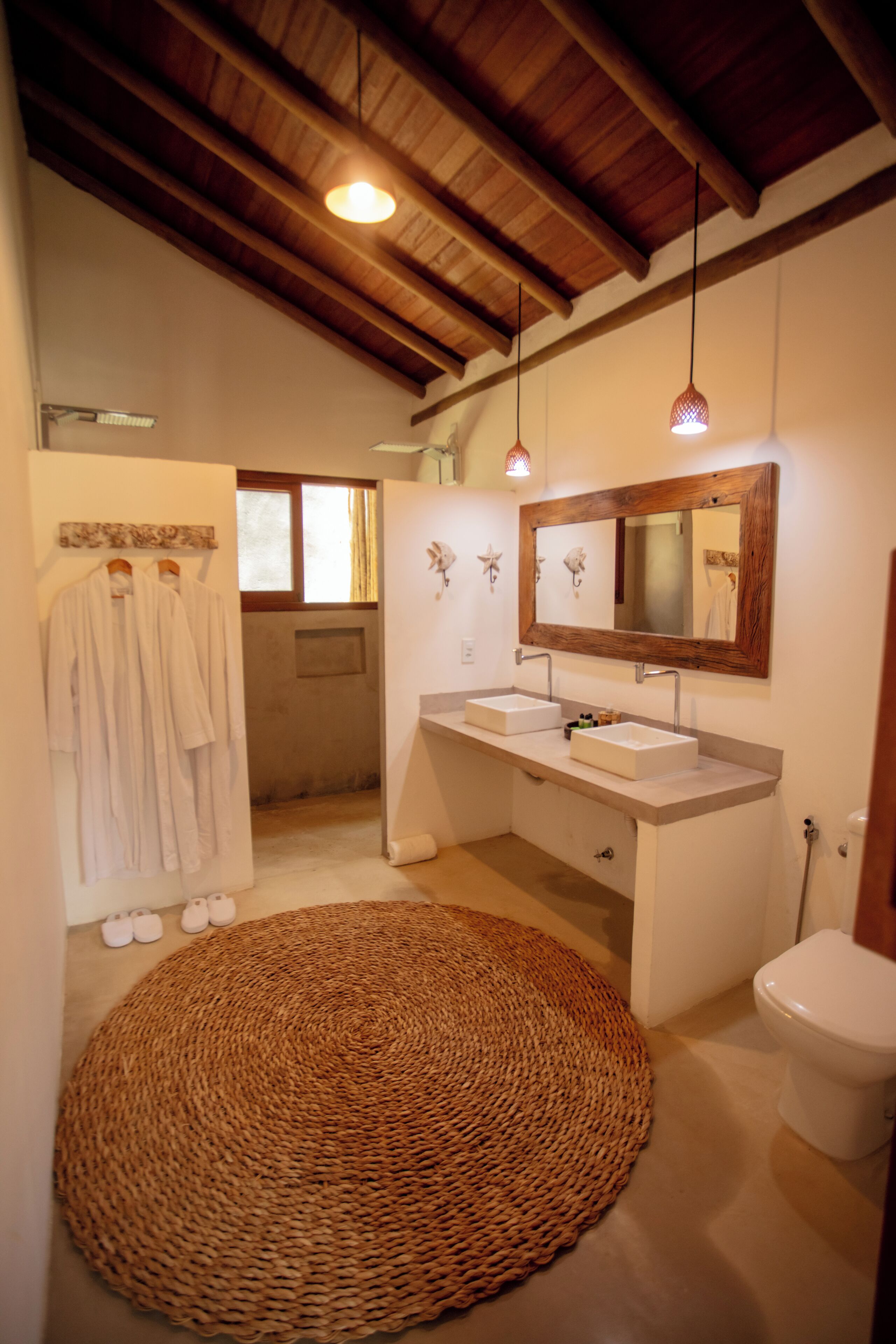 Ein Badezimmer mit Holzboden, zwei Waschbecken, einem großen Spiegel und einem Teppich.
