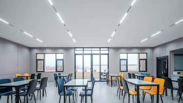 A conference room with tables and chairs, large windows, and a view of the city.
