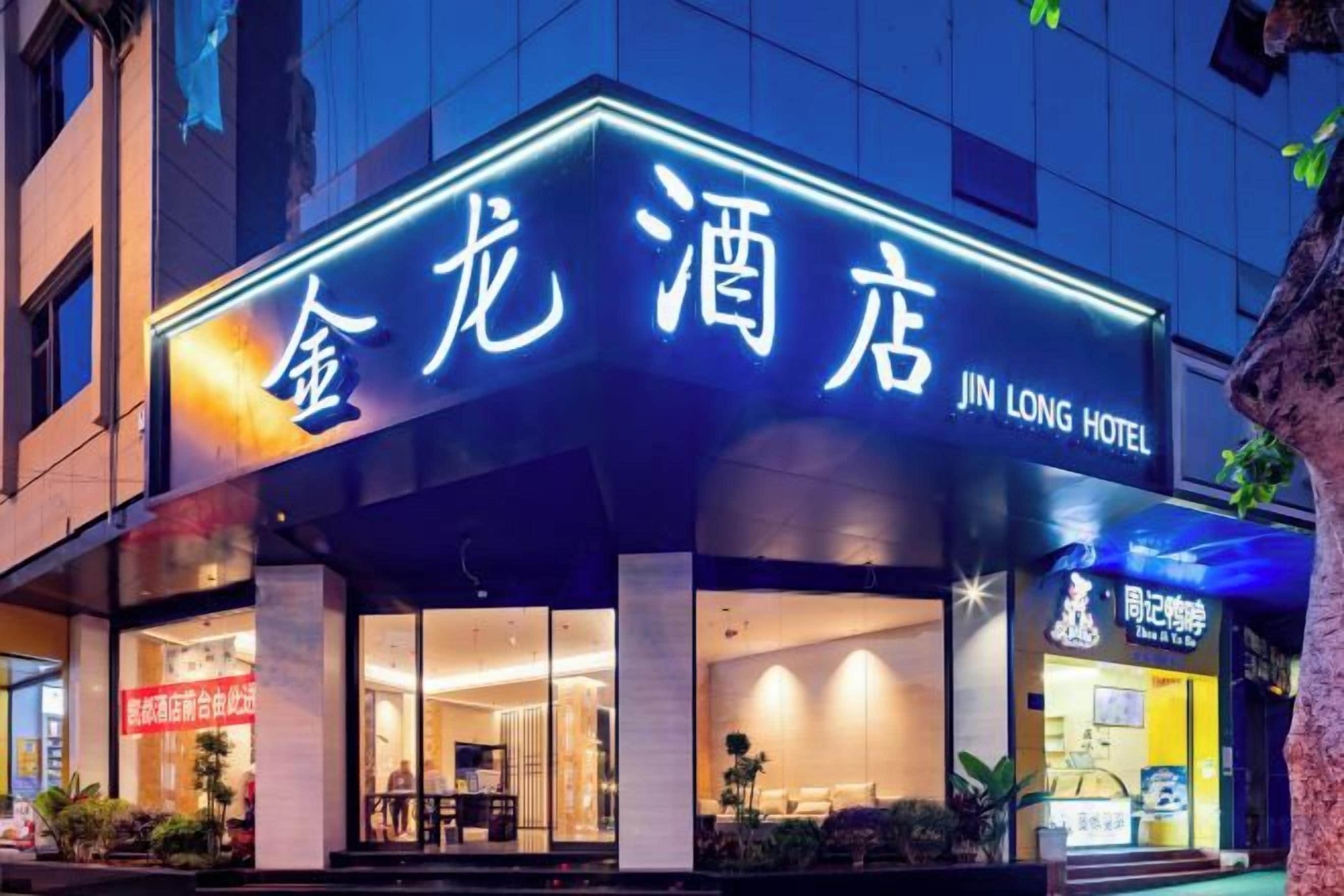 Un hotel con un cartel iluminado llamativo, un acceso cubierto y un escaparate visible.