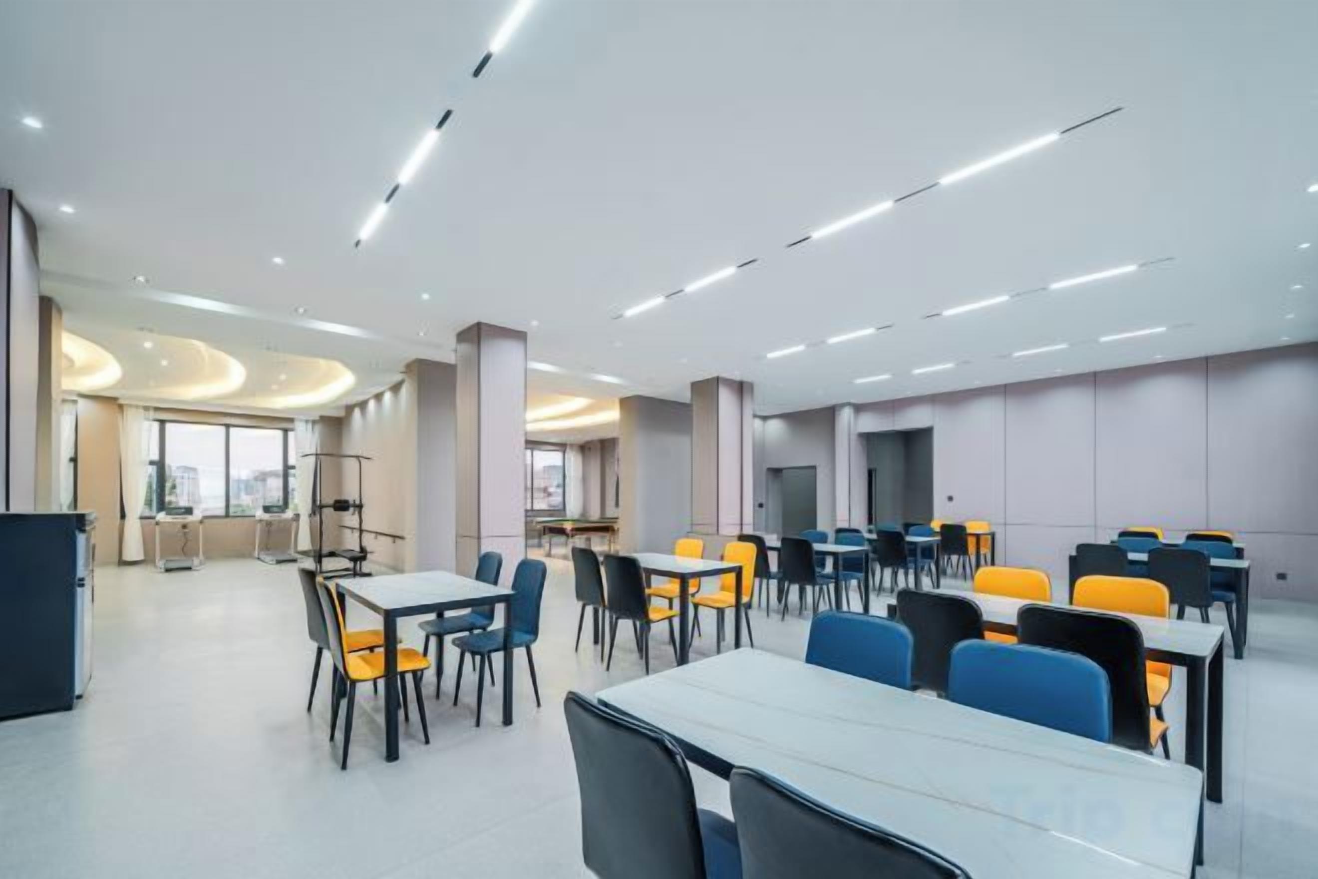 A modern dining area with tables and chairs, a large window, and a view of the city.