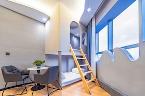 A modern room with a bunk bed, a small table with a plant, and a ladder. - Golden Dragon Hotel (Red River Maitreya Branch) (Mile)