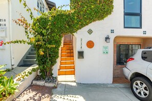 A white building with a spiral staircase, a resident parking sign, and a parked white car. - North Manhattan Beach Duplex with Ocean Views | 1 block to beach (Manhattan Beach)