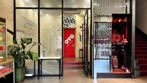 A modern interior with a red OYO sign, a staircase, and a display of red items. - HaoJiang Hotel (Huizhou)