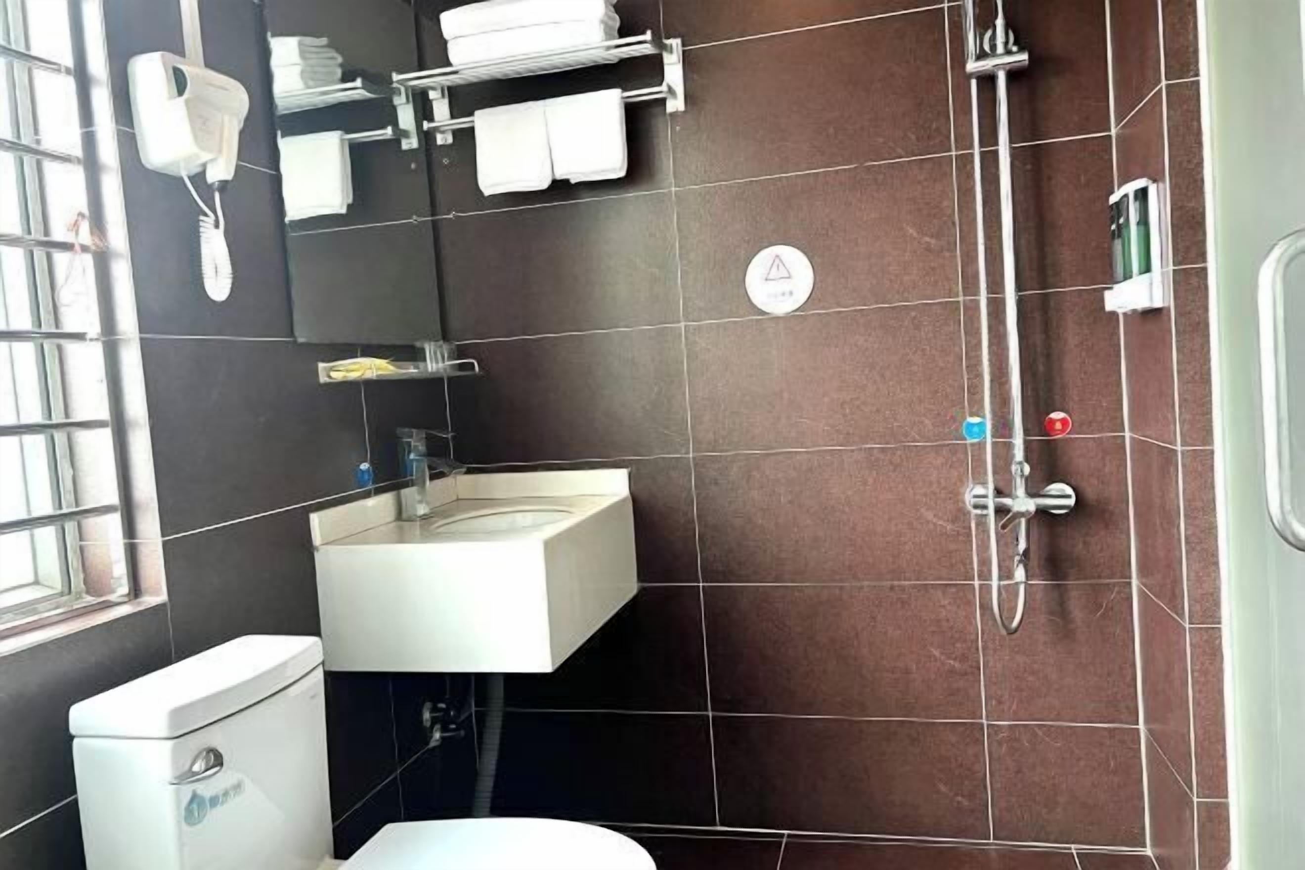 A bathroom with a toilet, sink, and shower.
