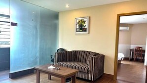 A modern living room with a striped sofa, a wooden coffee table, and a framed picture on the wall. - HaoJiang Hotel (Huizhou)