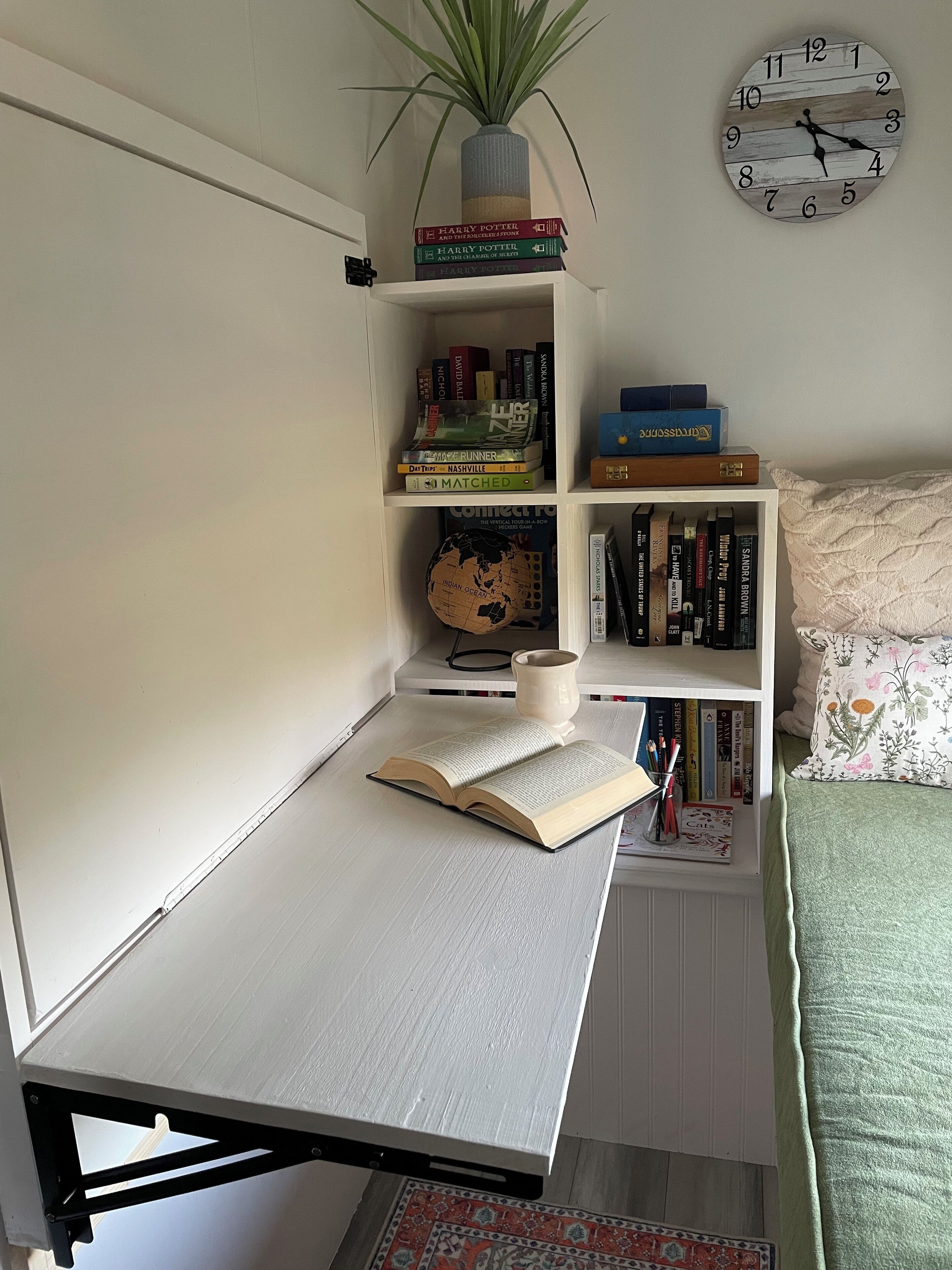 Un espacio de estudio con escritorio, estanterías, un globo terráqueo y un reloj.