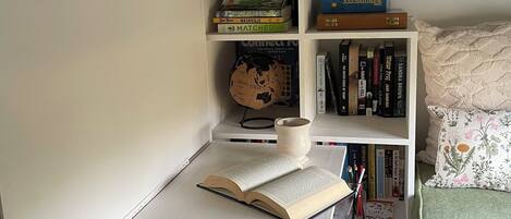 Un espacio de estudio con escritorio, estanterías, un globo terráqueo y un reloj.