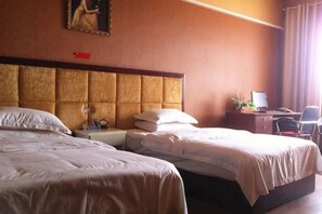 Une chambre d’hôtel avec deux lits, un bureau avec un ordinateur et une chaise.