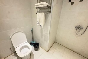 Un baño con inodoro, ducha, toallero y escoba.