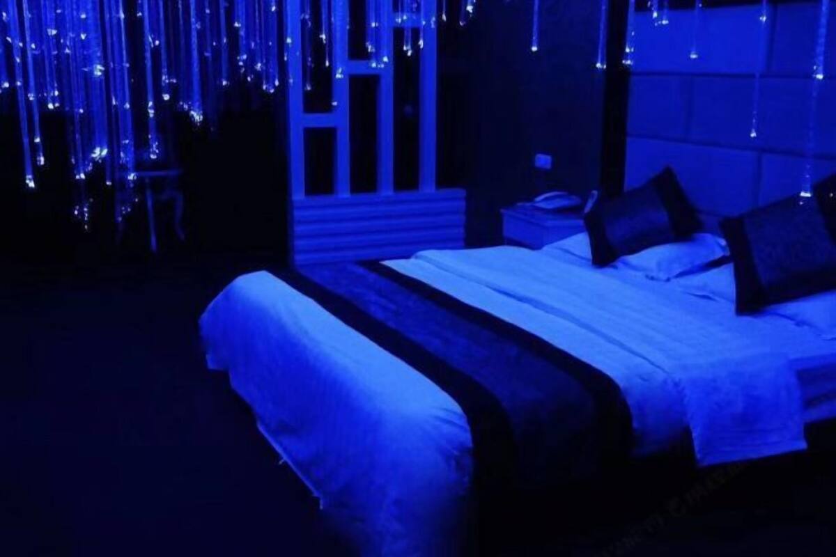 Un dormitorio con cama, mesitas de noche y ventana.