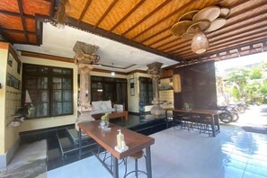A spacious indoor area with a wooden ceiling, a dining table with chairs, and a seating area with a sofa. - Coliving Bali Sweet Home Tabanan,Daily & Monthly Stay,Kost Bulanan (Bali)