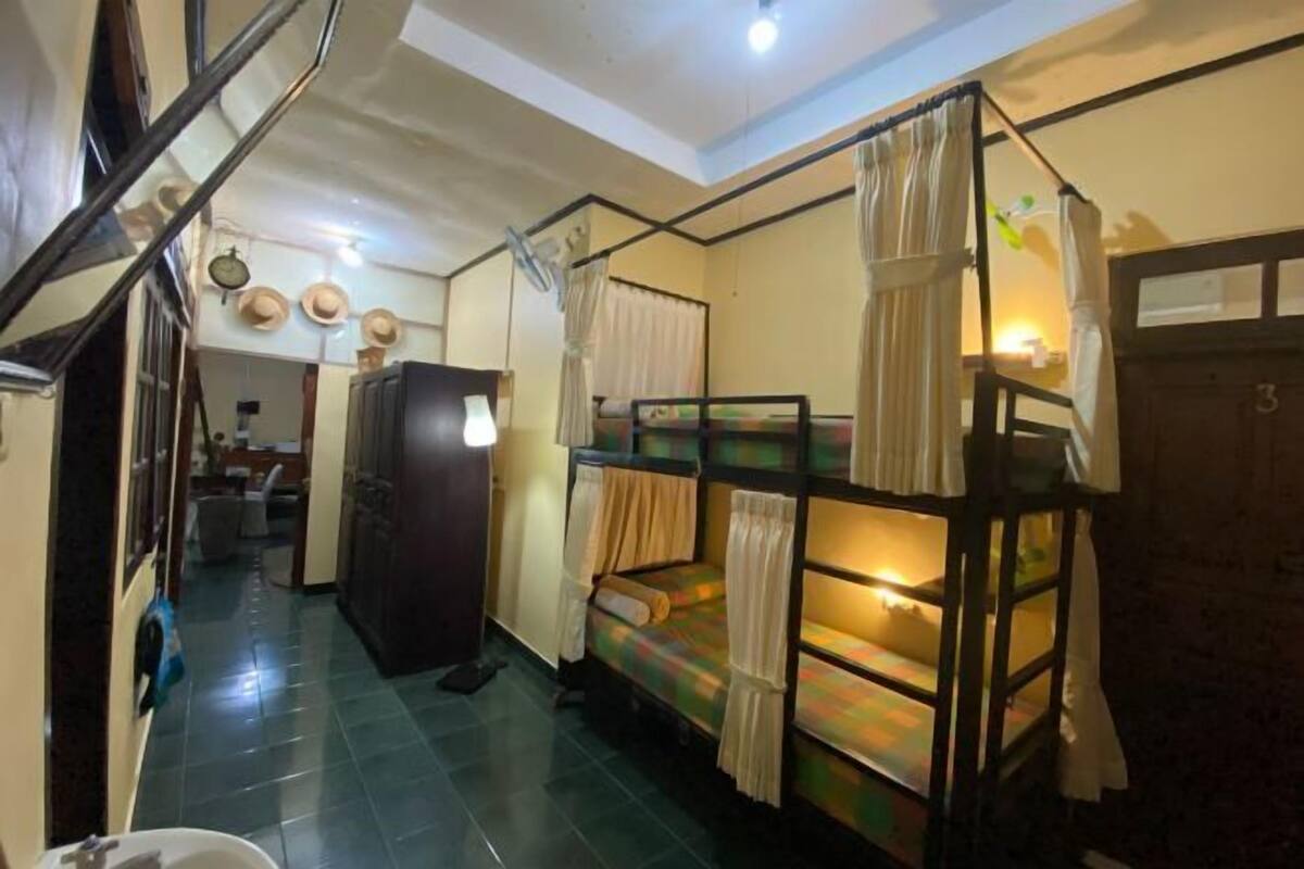 Une chambre de dortoir équipée de lits superposés, d’un réfrigérateur, d’un évier et d’un escalier.