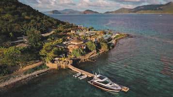 A coastal resort with a dock, clear waters, and lush greenery.
