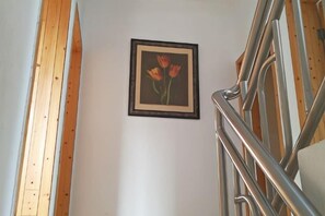 Una escalera con barandillas de metal y un cuadro en la pared con motivo de tulipanes.