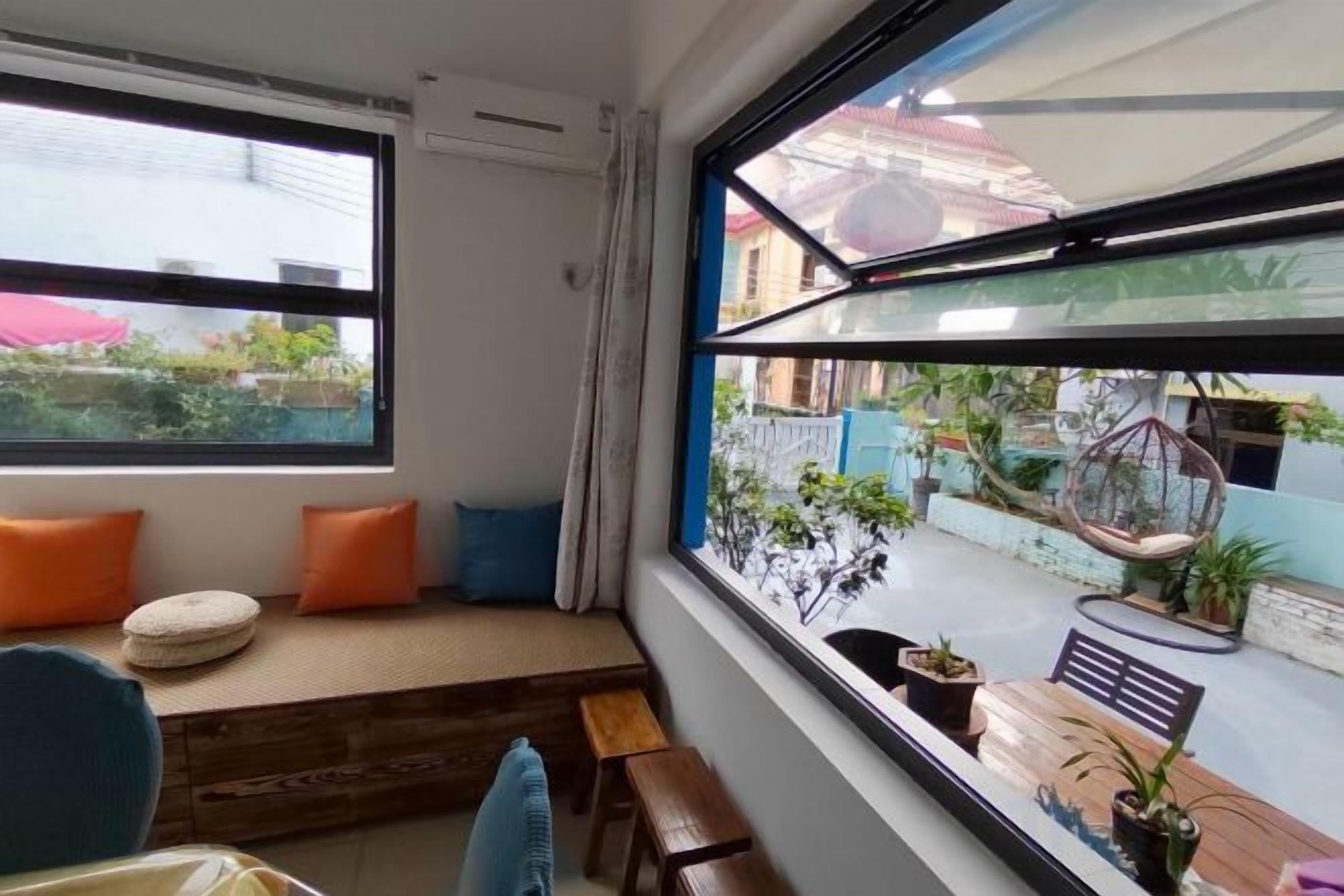 A room with a large window, a wooden bench, and a small table.
