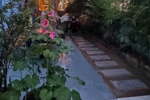A pathway with stepping stones leading through a garden with flowering plants. - Hola Inn (Shenzhen)