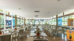 A spacious indoor dining area with white tables and chairs, large windows, and a 'Stay Hall' sign. - Flat 308D Marulhos-SH058 (Ipojuca)