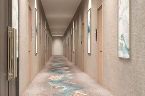 A long hallway with doors on both sides, a patterned carpet, and framed artwork on the walls. - Ewenki Qixin Dun Hotel (Ewenki Autonomous Banner)