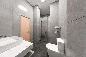 A modern bathroom with a large white sink, a toilet, and a shower area. - Ewenki Qixin Dun Hotel (Ewenki Autonomous Banner)