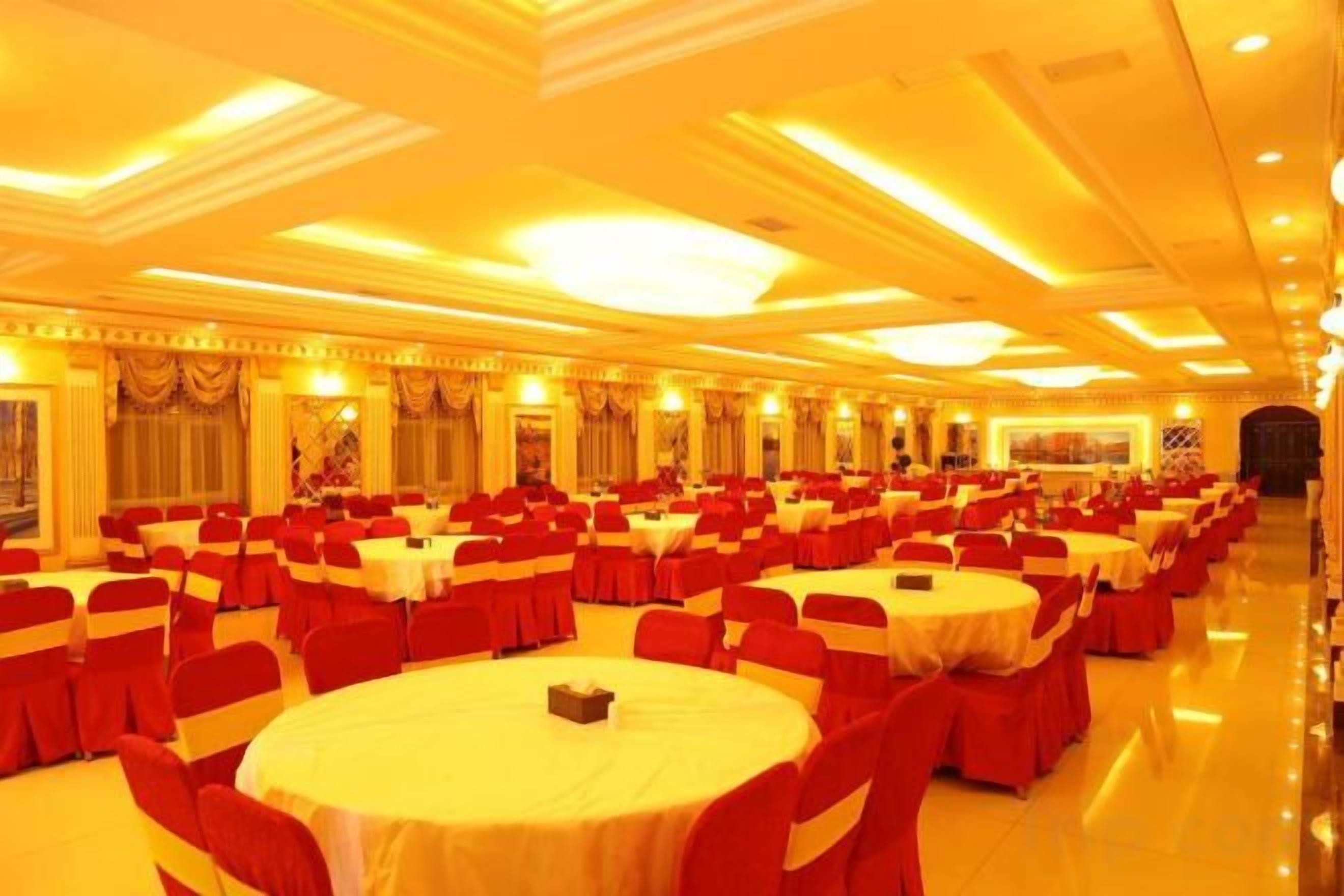 A banquet hall with multiple round tables and chairs, arranged in rows.