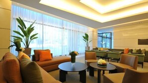 A modern lounge area with sofas, armchairs, and a coffee table. - Academy Hotel (Tainan)