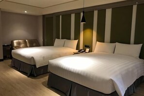 Una habitación de hotel con dos camas, una mesita de noche y una lámpara.
