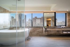 Une salle de bain moderne dotée d’une grande baignoire, d’une douche à parois de verre et d’un meuble-lavabo avec un miroir.