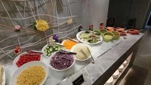 Un buffet proposant une variété de plats, notamment des salades, du riz et des légumes.