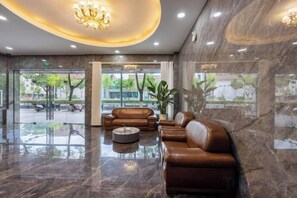 A lobby with a marble floor, leather seating, and a chandelier. - Jindu Hotel Danghu Street (Pinghu)