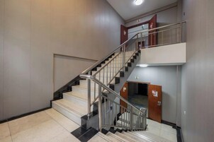 A staircase with metal railings and a landing area with a door.