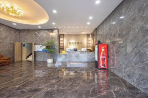 Un vestíbulo de hotel con una recepción, una escalera y un refrigerador de Coca-Cola.