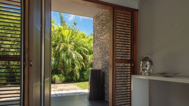 A modern interior with a view of lush greenery outside. - Very nice villa Indigo overlooking golf court (Saint François)