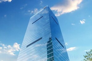 A tall, modern glass skyscraper with a clear sky in the background. - Beiai Hotel (Chongqing Daping Longhu Times Tianjie) (Chongqing)