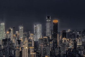 A nighttime cityscape with illuminated skyscrapers.