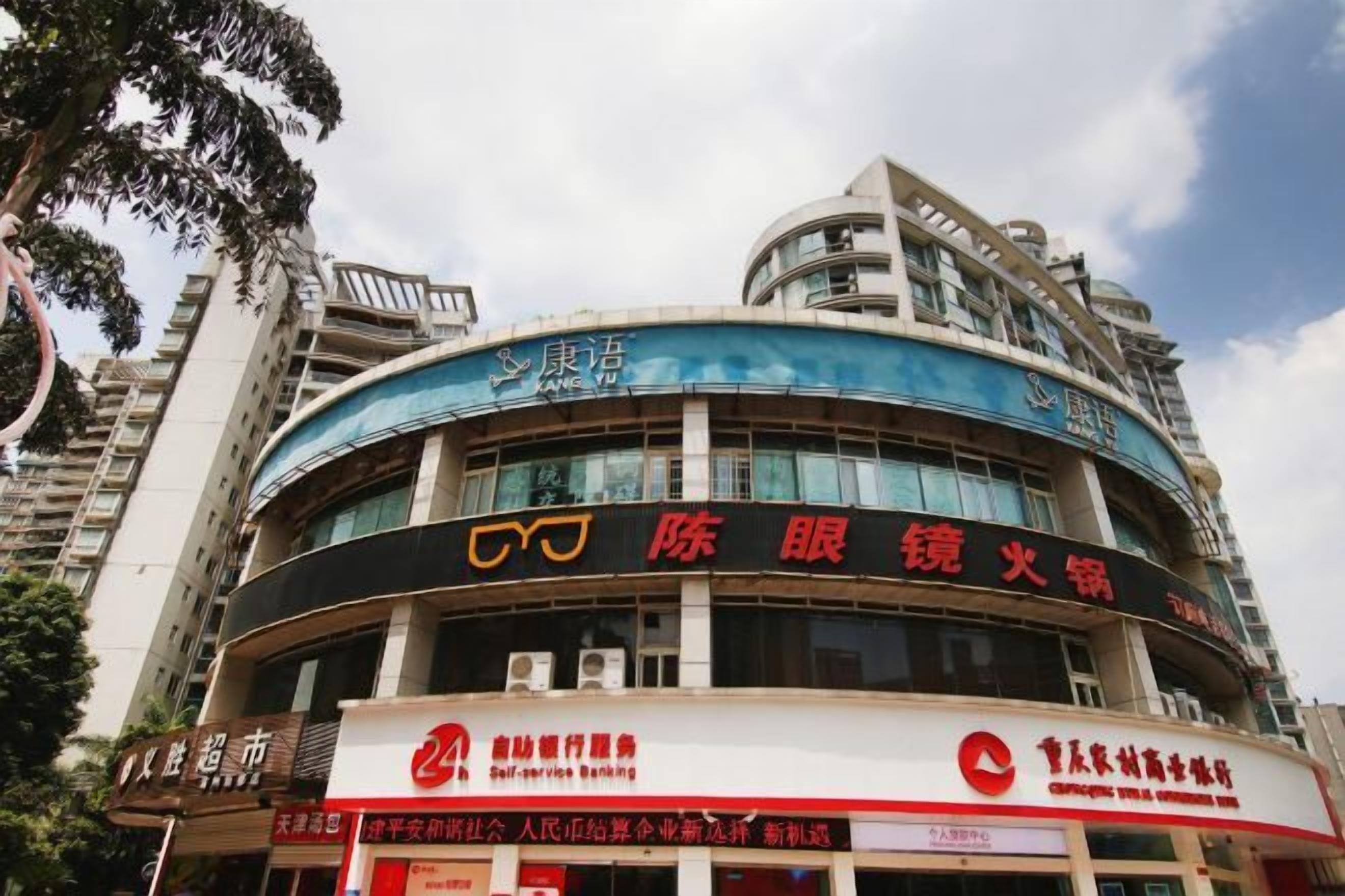 A multi-story building with signage for a bank and a self-service banking service.