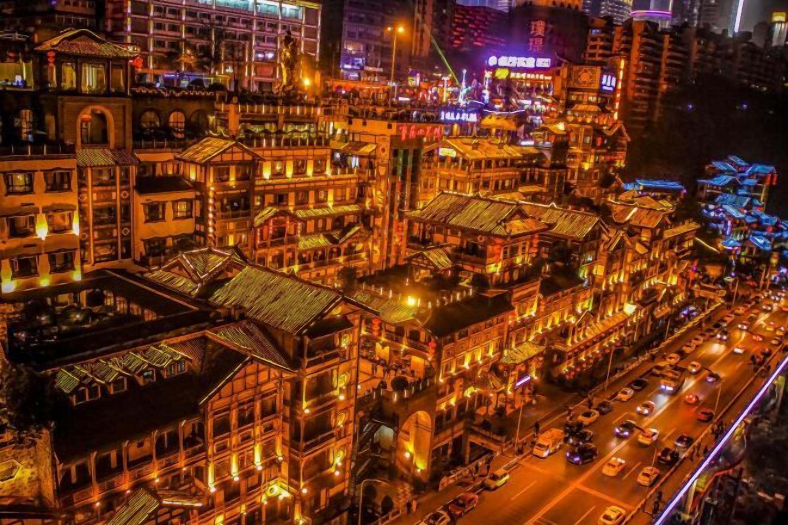 A densely packed urban street at night with traditional architecture and illuminated signage.