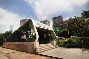 A modern building with a curved facade, a glass entrance, and a sign indicating a public space. - Beiai Hotel (Chongqing Daping Longhu Times Tianjie) (Chongqing)