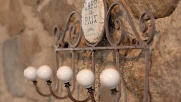 Un estante metálico de pared con un letrero que dice 'CAFÉ DE PAIX' y cinco objetos esféricos blancos colgando de él.