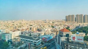 Un paysage urbain caractérisé par des bâtiments denses, une tour imposante et un ciel dégagé.