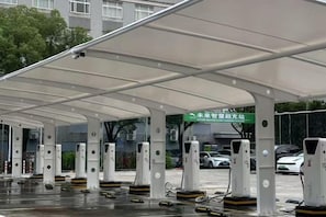 Un área de estacionamiento techada con múltiples estaciones de carga para vehículos eléctricos.