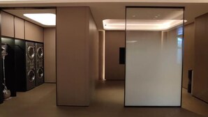 Een moderne hotelkamer met een grote spiegel, een flatscreen-televisie en een ingebouwde wasmachine en droger.