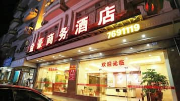 A hotel with a large illuminated sign, a reception area, and a visible entrance.