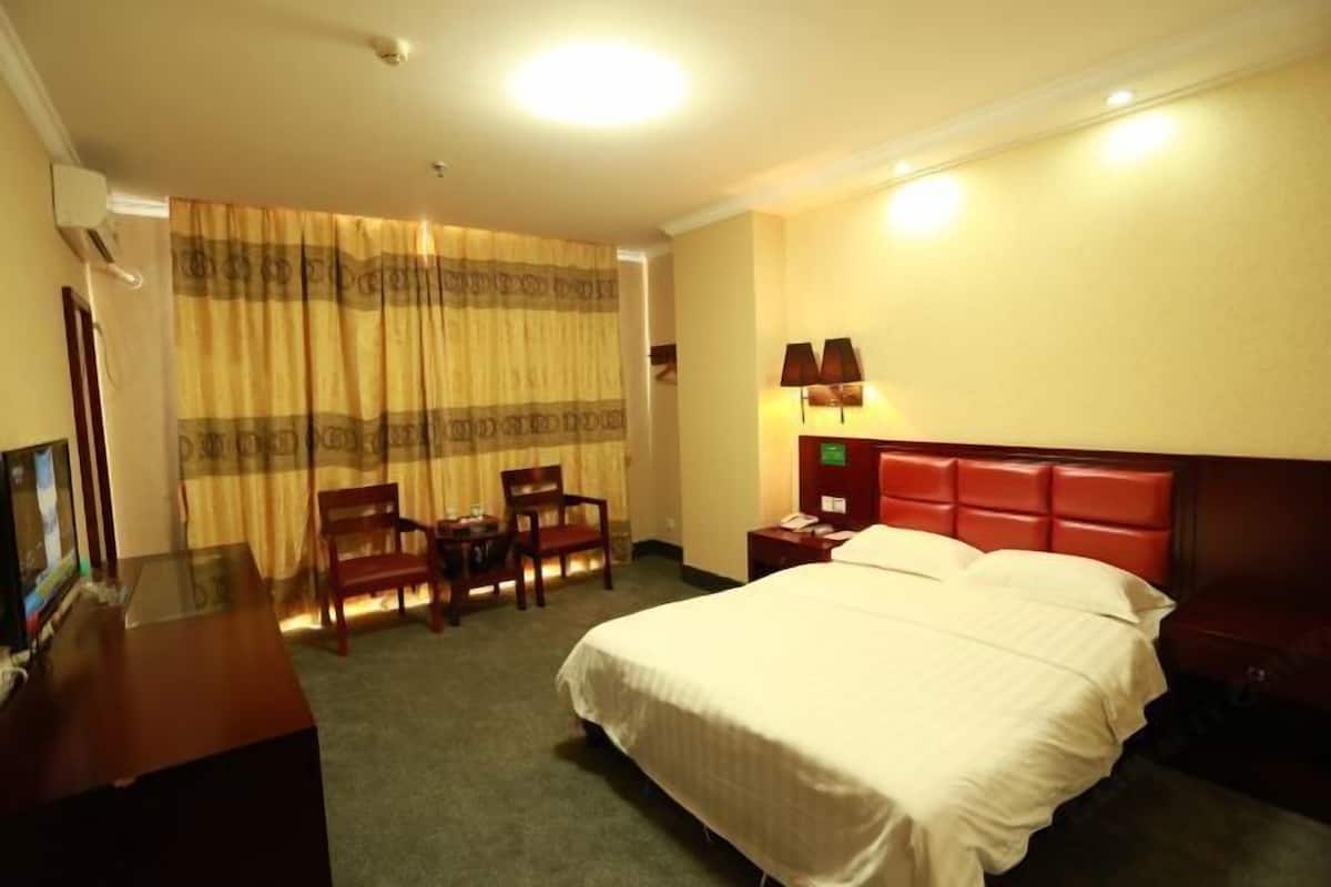 Une chambre d’hôtel avec un lit, un bureau et une chaise.