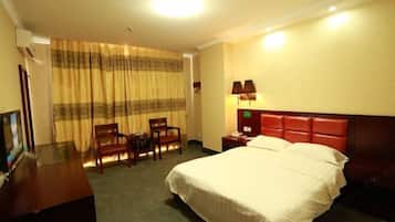 Una camera d'albergo con un letto, una scrivania e una sedia.