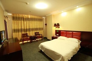 Una habitación de hotel con una cama, un escritorio y una silla.