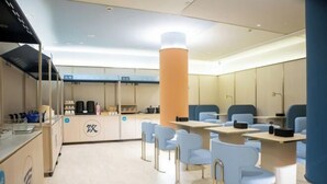 A modern restaurant with a central counter, blue chairs, and a minimalist design. - HanTing Hotel (Jiande Xin'an River Xindian) (Jiande)