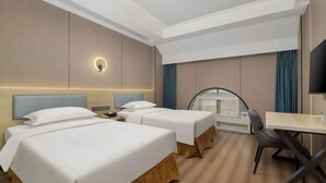 A hotel room with two beds, a desk, and a curved mirror. - Halcyon Hotel & Resort (Yingtan)