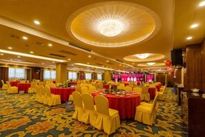 A banquet hall with round tables, yellow chairs, and a carpeted floor. - Halcyon Hotel & Resort (Yingtan)